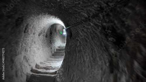 Stone steps leading deeper into the Vardzia cave monastery, an ancient marvel carved into the Erusheti cliffs during the Middle Ages, illuminated by a single light revealing the rough-hewn walls