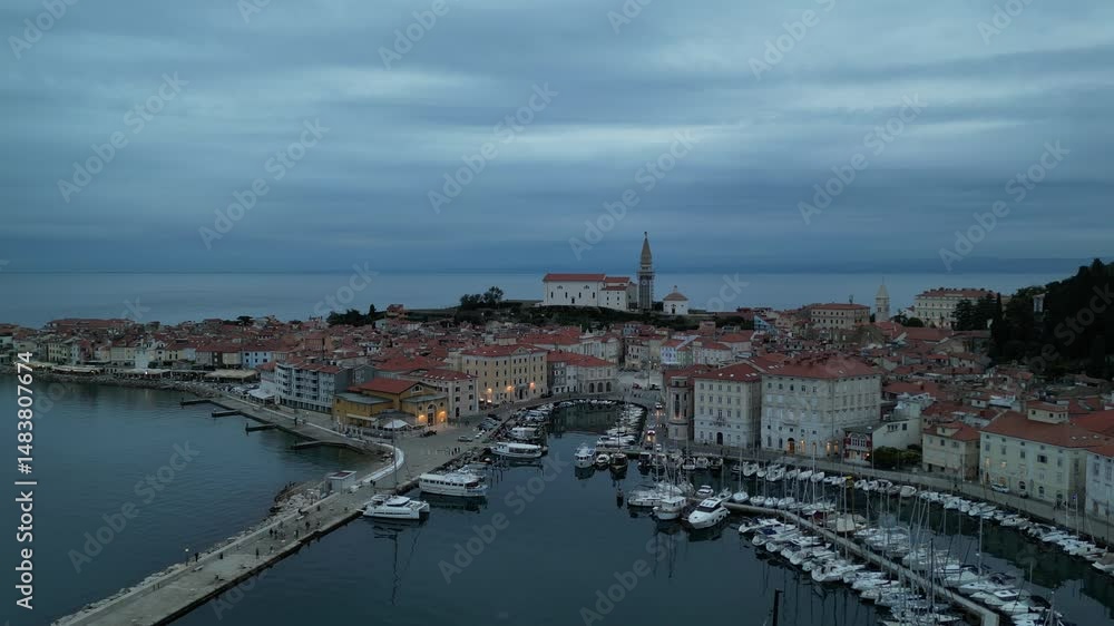 aerial view of piran slovenia at dusk blue hour after sunset (red roof buildings lighthouse Mediterranean sea coast on istrian peninsula) travel tourism resort beach town europe european destination aerial view of piran slovenia at dusk blue hour after sunset (red roof buildings lighthouse Mediterranean sea coast on istrian peninsula) travel tourism resort beach town europe european destination