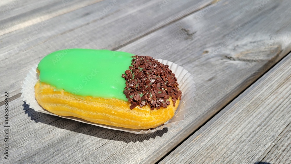 Φωτογραφία Gland au kirsch avec glaçage vert sur table en bois à l'extérieur