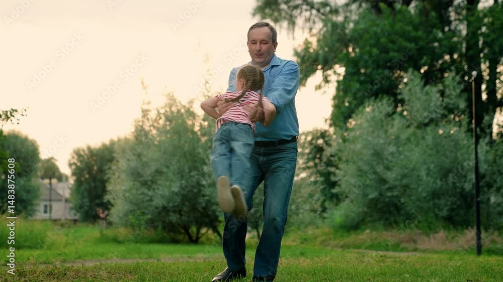 Child happily play with father. Father spins child. Child, daughter, dad play together carefree in summer park, days Spin with kid. Dad plays with her child, spins her joyful girl. Happy family, baby. Child happily play with father. Father spins child. Child, daughter, dad play together carefree in summer park, days Spin with kid. Dad plays with her child, spins her joyful girl. Happy family, baby.
