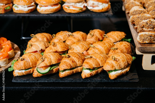 Mini croissant sandwiches on catering display.