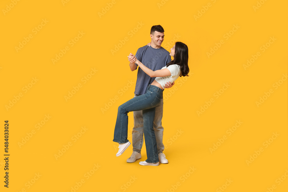 Beautiful young couple dancing on yellow background Beautiful young couple dancing on yellow background