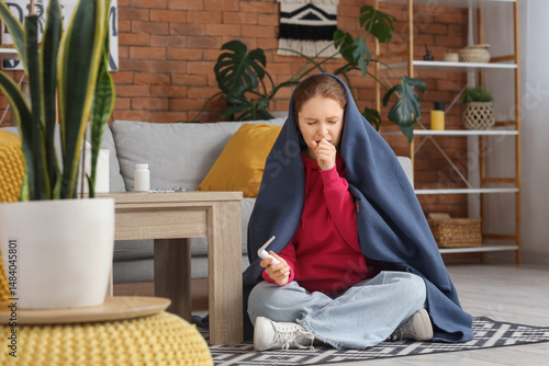 Sick young woman wrapped in...