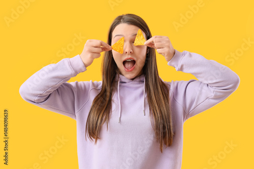 Wallpaper Mural Shocked young woman with tasty nachos on yellow background Torontodigital.ca