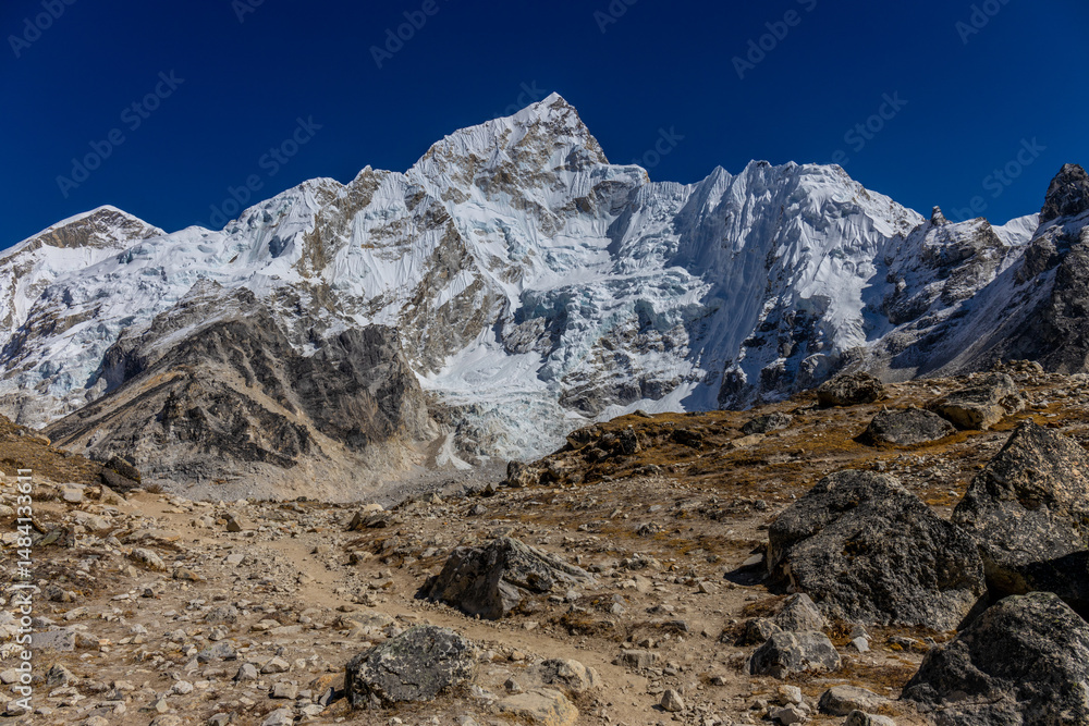 Fototapeta premium Nuptse mountain summit in Nepal. Himalaya glaciers trek, Nepal high altitude trekking. Stunning mountain views at Nepal Everest Base Camp trek, hiking among the huge snow peaks in Himalayas