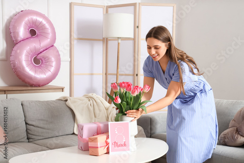 Young woman putting tulips ...