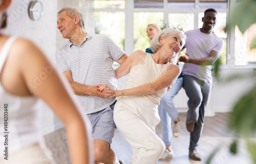 Senior europian man is enjoying his hobby of dancing salsa with his elderly partner at fitness class, relishing in movement and activity. It great way for them to stay active and have fun together.