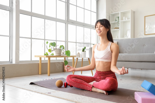 Sporty young woman meditati...