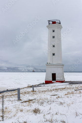 Wallpaper Mural Leading beacon on the snowy shore of the sea bay. The coast of the Sea of ​​Okhotsk. The sea bay is covered with ice. An icebreaker and mountains are visible in the distance. City ​​of Magadan, Russia Torontodigital.ca