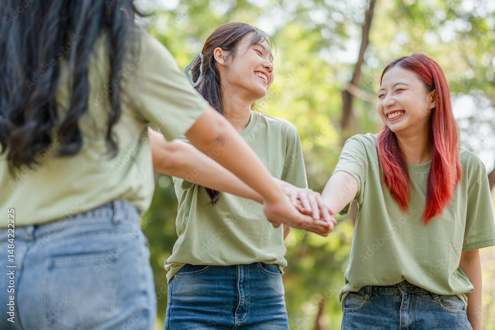 Group of Happy Asian female volunteers team in park for charity event with joining hands Group of Happy Asian female volunteers team in park for charity event with joining hands