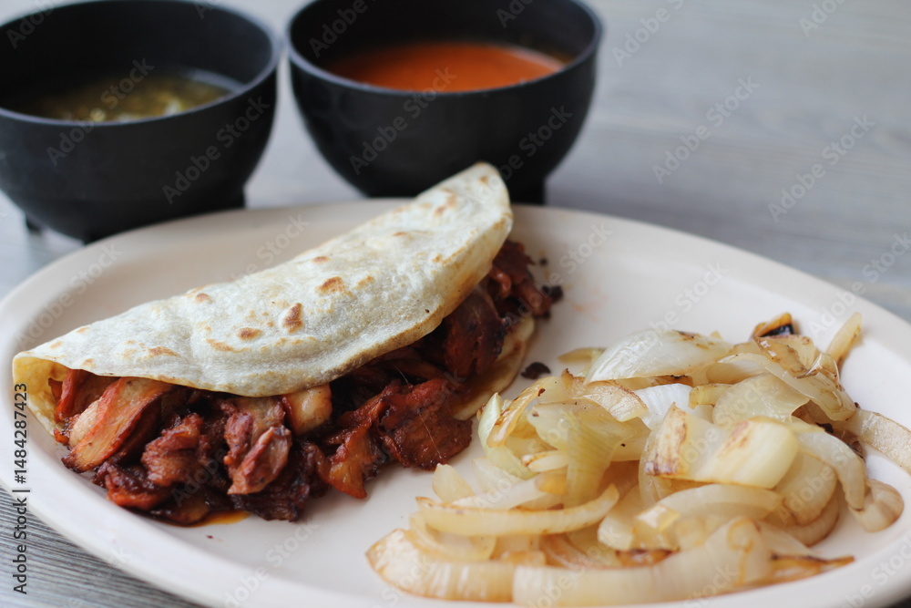 Authentic al pastor taco made with flavorful meats, served with sautéed onions and vibrant sauces, representing the essence of traditional street food in a colorful presentation. Authentic al pastor taco made with flavorful meats, served with sautéed onions and vibrant sauces, representing the essence of traditional street food in a colorful presentation.