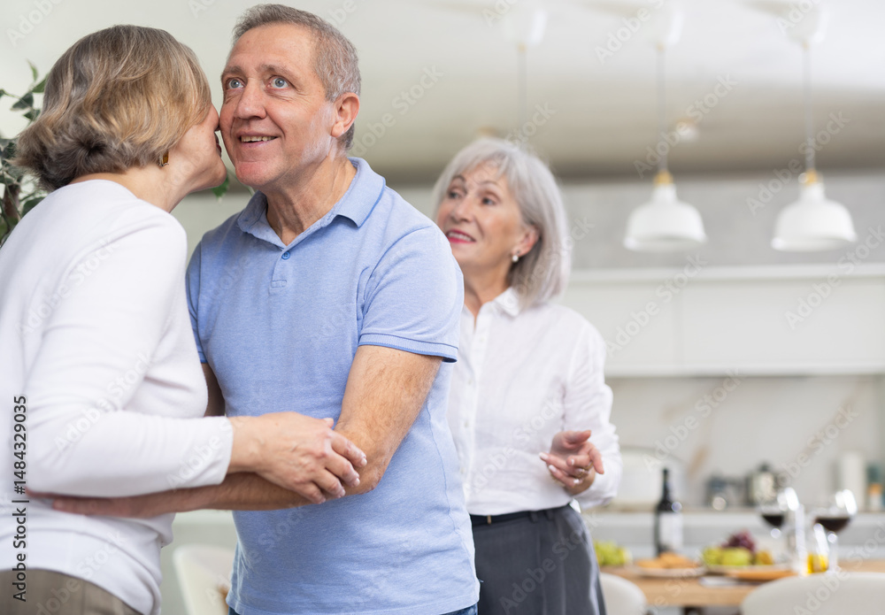 Obraz premium Two elderly couples meet for a holiday dinner at home. Greet each other