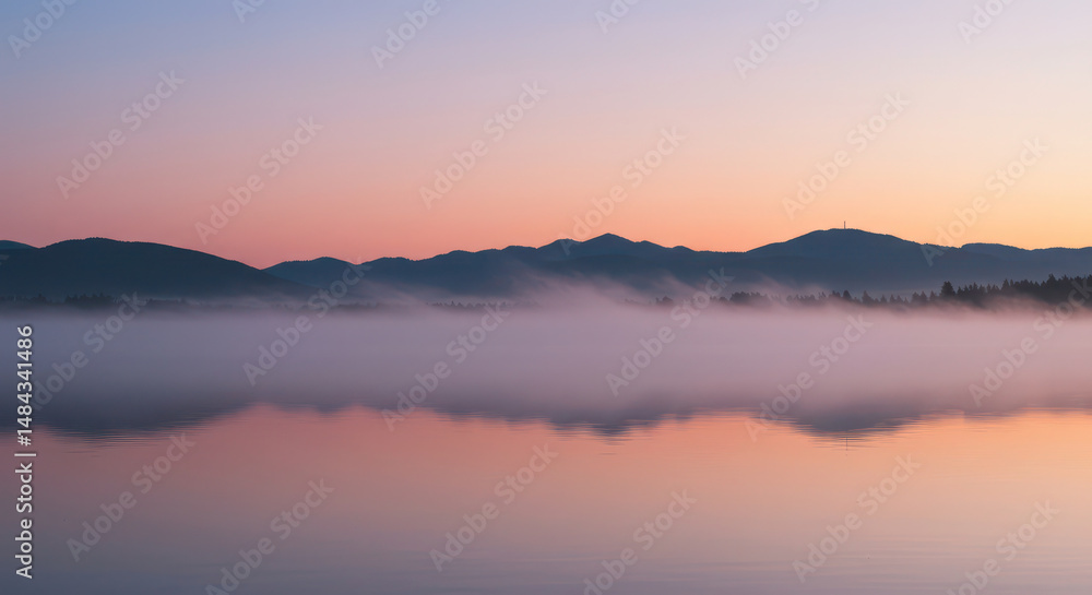 Dreamy dawn over a tranquil lake with mist and mountainous reflections Dreamy dawn over a tranquil lake with mist and mountainous reflections