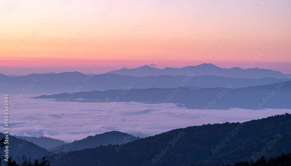 Fototapeta premium Sunrise light shining over misty mountain hills and valleys
