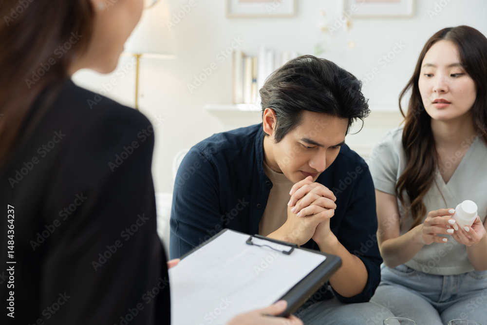 Couple seated across therapist in counseling session, husband shows signs of burnout and workplace failure, receiving psychological support, working through depression, emotional care and advice Couple seated across therapist in counseling session, husband shows signs of burnout and workplace failure, receiving psychological support, working through depression, emotional care and advice