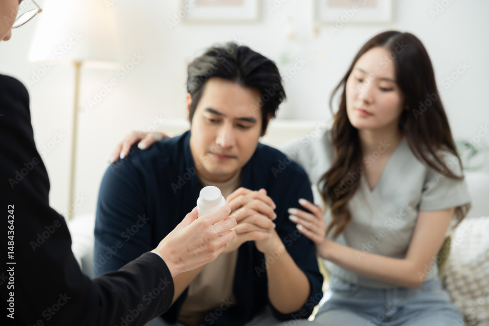 Couple seated across therapist in counseling session, husband shows signs of burnout and workplace failure, receiving psychological support, working through depression, emotional care and advice Couple seated across therapist in counseling session, husband shows signs of burnout and workplace failure, receiving psychological support, working through depression, emotional care and advice