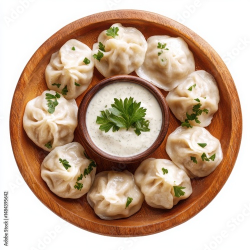 Momos with sauce on a wooden plate on a white background