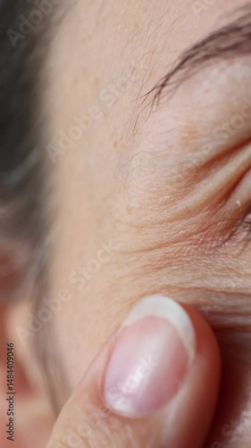 Close up view of woman eyes. Macro shot of middle aged female wrinkles near the eyes. Concept of aging, old skin of wrinkled face of caucasian. Beauty portrait. Vertical video.