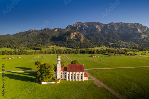 Aerial view of tall St Coloman church near Schwangau town Bavaria, Germany in evening sun light.