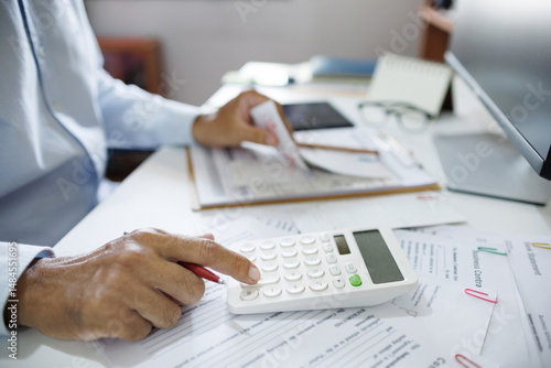close-up shot, accountants working in office use calculators to calculate business costs, profits and tax