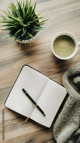 Open journal with pen and green matcha tea on beige fabric with sunlight shadows and eucalyptus plant creating peaceful calm minimal workspace in natural soft morning light and neutral tones