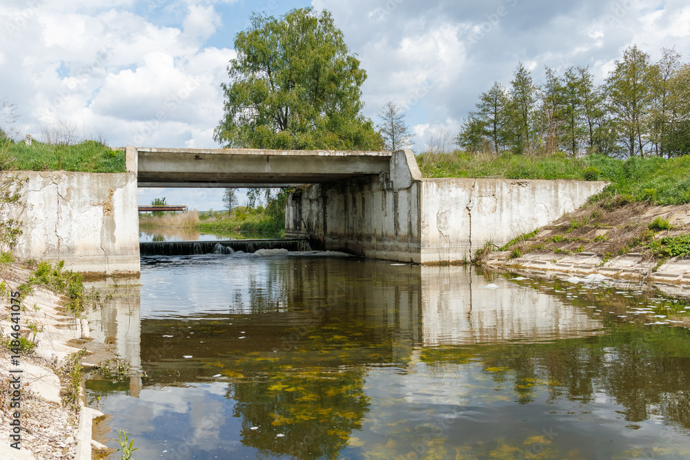 Fototapeta premium Concrete flood control bridge over river with weir