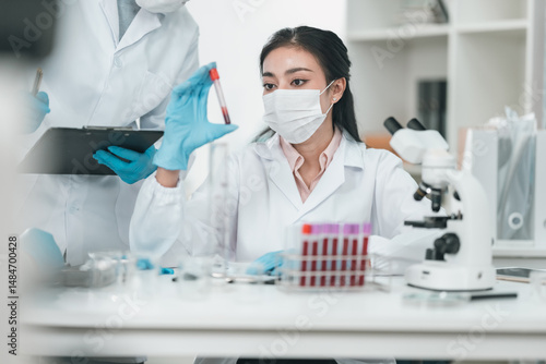Medical research team conducting health and pharmaceutical experiments using blood samples in laboratory to develop advanced treatments and vaccines for global healthcare innovation