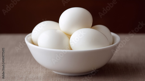 Bowl of peeled hardboiled eggs with smooth glossy white shells