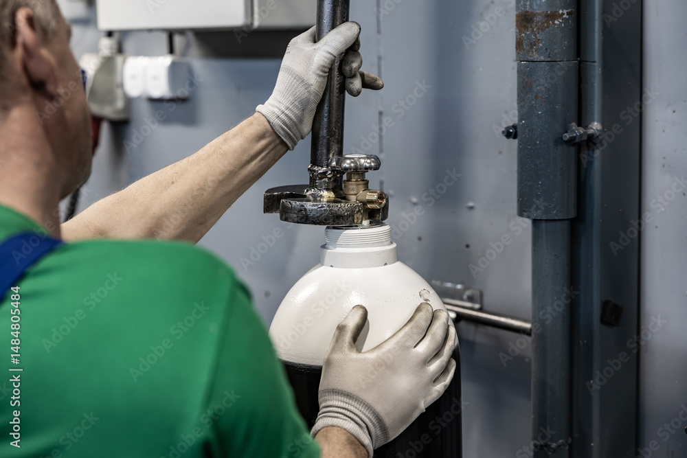 Close-up of gloved hands attaching a black and white gas cylinder to a pipe system in an industrial setting Close-up of gloved hands attaching a black and white gas cylinder to a pipe system in an industrial setting