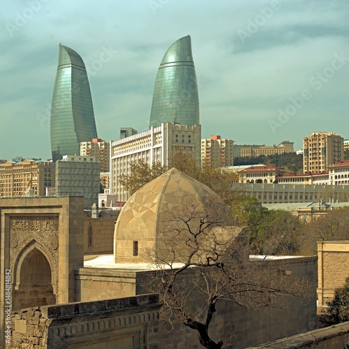 Baku city, Azerbaijan, view of historic mosques and walls of the Shirvanshahs Palace in the Old City and modern glass Flame Towers