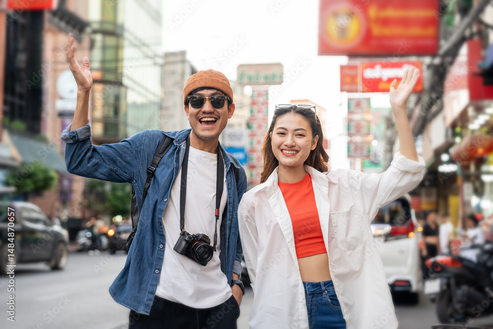 Obraz premium Asian couple man and woman enjoy eating street food noodle at night market. Traveler Asian couple blogger Happy tourists with Traditional food local road at thailand bangkok city.