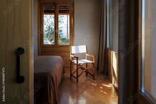 Minimalist bedroom with wooden furniture and sunlight streaming through the window photo