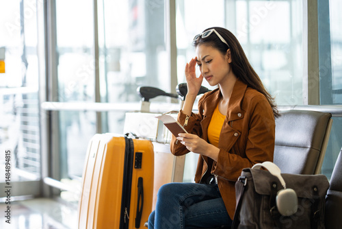 Obraz na płótnie Unhappy young woman traveler disappointed with flight delay or cancelation while waiting at airport terminal, female tourist upset after receiving bad news when sitting at airline lounge