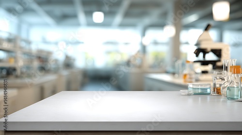 White counter top in a laboratory with microscope and glassware blurred in the background showing science research environment