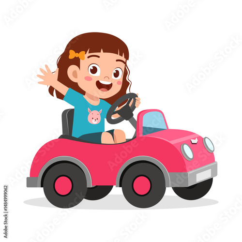 Happy girl driving a toy car, waving hand, wearing blue shirt with smiling face illustration