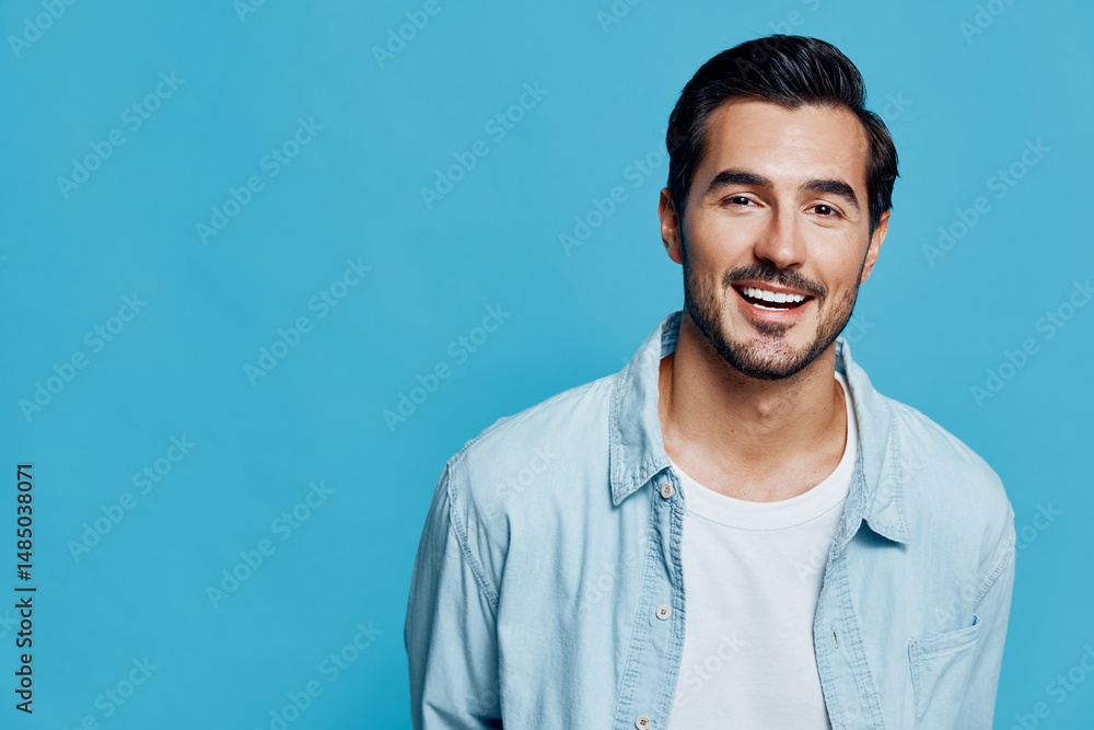 Smiling man dressed in light blue shirt stands against a bright blue background, showcasing a cheerful expression and a vibrant personality. Portrait concept. Smiling man dressed in light blue shirt stands against a bright blue background, showcasing a cheerful expression and a vibrant personality. Portrait concept.