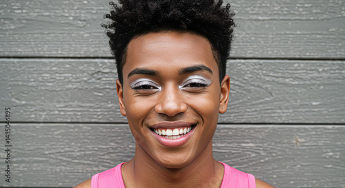 Smiling Man with Unique Eye Makeup Against Wood Background
