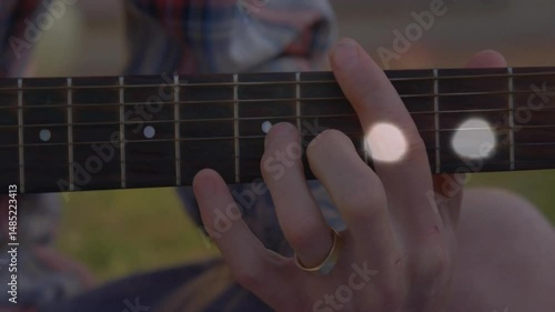 Guitar musician pressing chord outdoors, displaying animated chord diagram and floating music notes