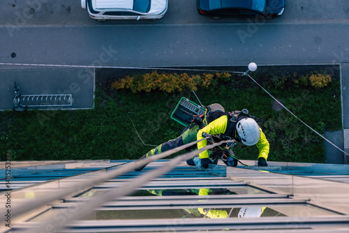 Rope access specialist washes the facade of a building