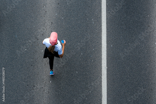 Running woman on the road, top view