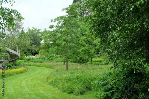 a garden with a bridge and a green lawn