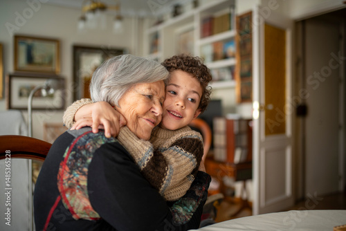 Grandson hugging grandmother at home showing love and affection