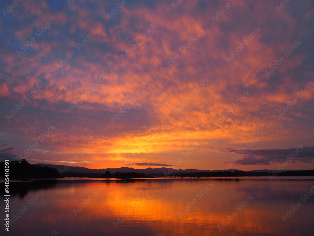 Sunset with golden glow and rosy clouds in sky and river Sunset with golden glow and rosy clouds in sky and river