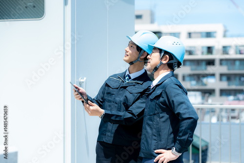 現場で打ち合わせする作業服のビジネスマン