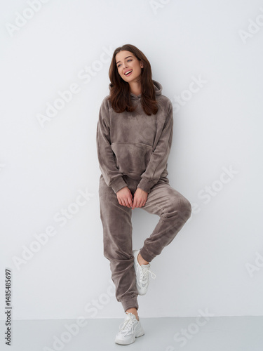 Stylish young woman modelos casual loungewear in a minimalistic studio setting