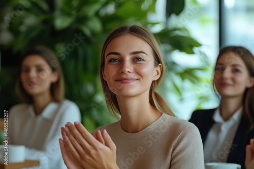 Wallpaper Mural Crowd of women engaged in a meeting with one woman clapping and smiling in a well-lit modern space surrounded by green plants Torontodigital.ca
