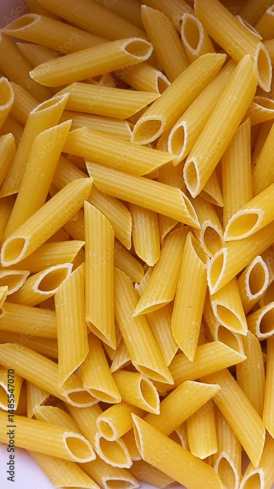 Uncooked pasta background, penne pasta view Uncooked pasta background, penne pasta view