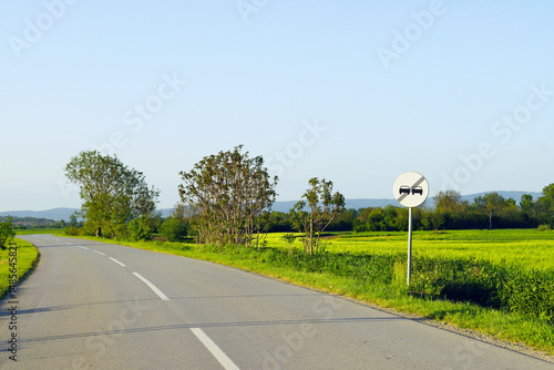 Foto Road trip in Serbia: view of a turning asphalt road with two lanes and markings