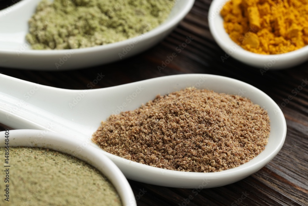 Different superfood powders in spoons on wooden table, closeup Different superfood powders in spoons on wooden table, closeup