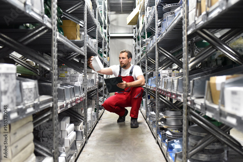 portrait friendly worker in a warehouse and trade for car spare parts of a car repair shop